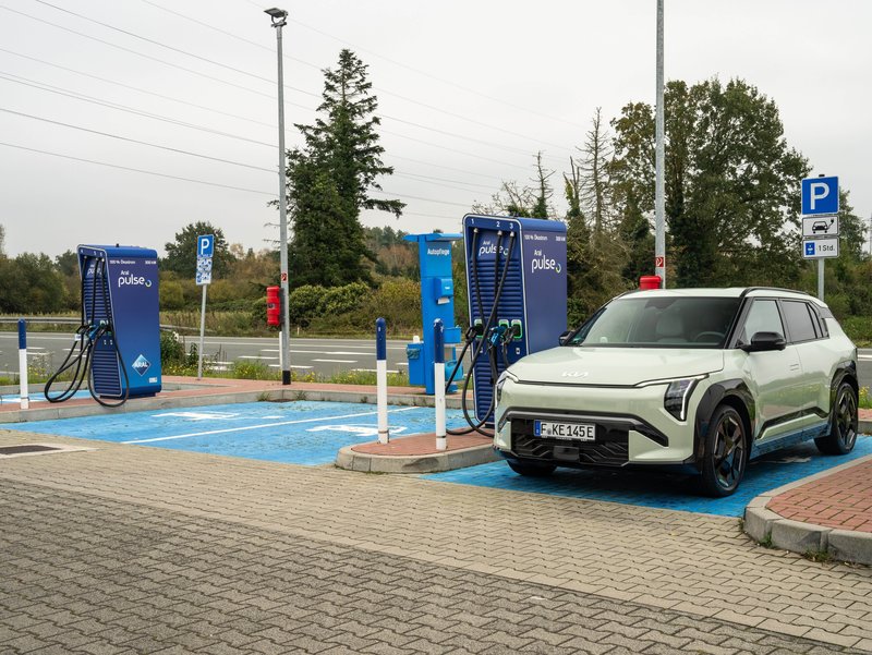 E-Auto an Ladesäule. E-Auto steht auf einem Parkplatz an einer Ladestation.